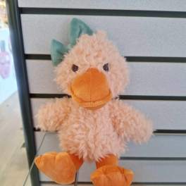 Small plush duck toy with fuzzy peach body, orange beak and feet, and a green bow.