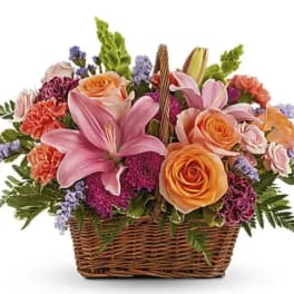 Basket of pink lilies and peach roses with purple filler flowers