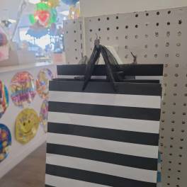 Black-and-white striped gift bag hanging on a display peg