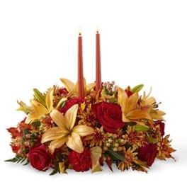 Autumn floral centerpiece with red roses and two taper candles