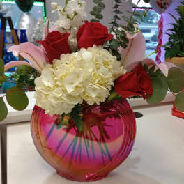 Bouquet of red roses and white hydrangeas in a pink glass vase