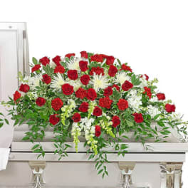 Red roses and white flowers arranged on a casket