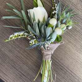 Boutonniere with a white rose and blue-green foliage