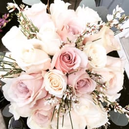 Bouquet of pale pink and white roses with small white filler flowers