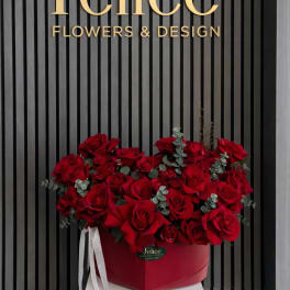 Red roses arranged in a heart-shaped box with ribbon accents