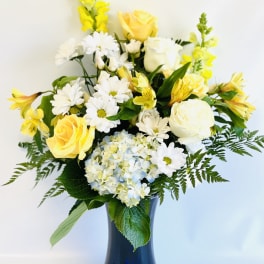 Yellow and white flowers arranged in a blue vase