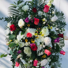 Large standing floral spray with roses, white blooms, and greenery