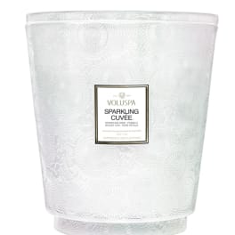 White patterned candle in a glass vessel with a label