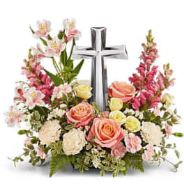 Floral arrangement with a silver cross and pink roses