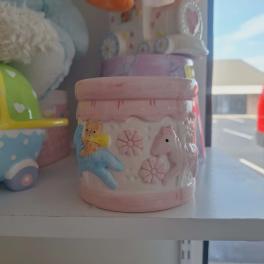 Pink ceramic jar with a teddy bear and horse reliefs
