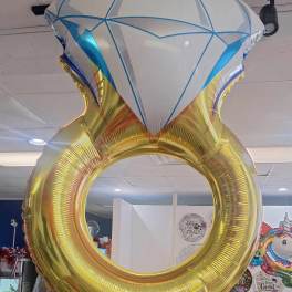 Large diamond ring-shaped foil balloon hanging indoors
