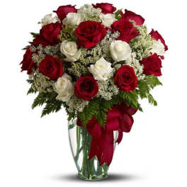Bouquet of red and white roses in a clear glass vase with a red ribbon