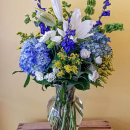 Blue and white flower arrangement in a clear glass vase