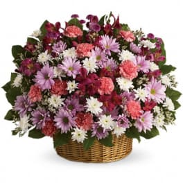 Mixed pink, purple, and white flowers in a wicker basket