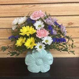 Mixed bouquet in a light blue flower-shaped vase