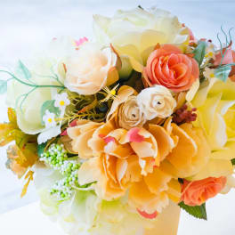 Bouquet of cream, peach, and yellow roses with small white accents