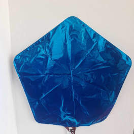 Blue star-shaped foil balloon on a white wall