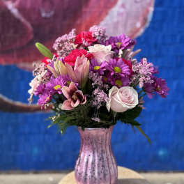 Pink and purple mixed bouquet in a pink glass vase
