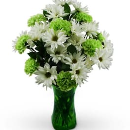 White daisies and green carnations in a green glass vase