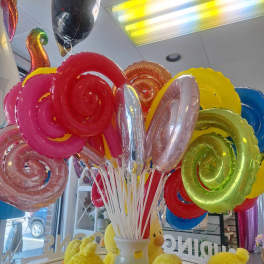 Colorful spiral balloons in a vase with yellow plush chicks