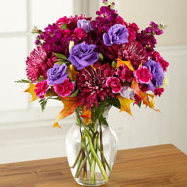 Bouquet of magenta and purple flowers in a clear glass vase