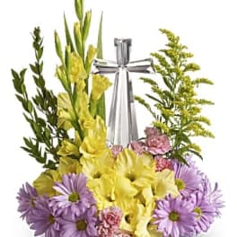 Yellow and lavender floral arrangement with a silver cross centerpiece