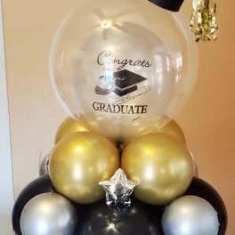 Graduation balloon arrangement with a clear congratulatory balloon and gold and black balloons