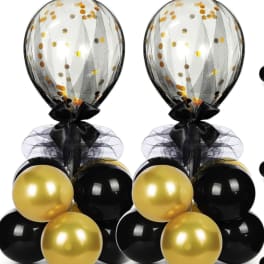 Two black and gold balloon bouquets with clear confetti balloons on top