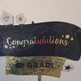 Graduation-themed foil balloons with "Congratulations" and "GRAD!" text