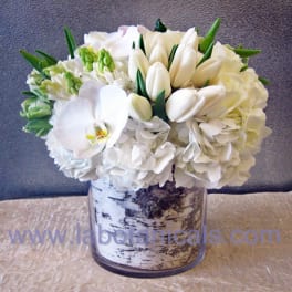 White floral arrangement in a birch-pattern vase