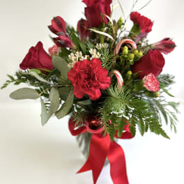 Red roses and carnations with candy canes and a red ribbon