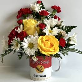 Bouquet of yellow roses, white daisies, and red carnations in a soup mug
