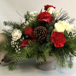 Holiday floral arrangement with red and white carnations in a stone vase