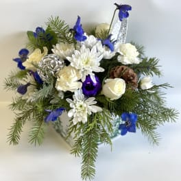 White and blue floral arrangement with pine branches and ornaments