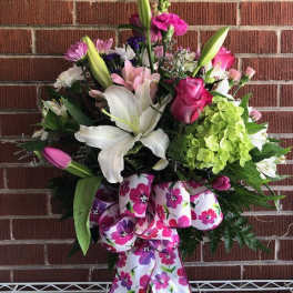 Mixed bouquet with lilies, roses, and hydrangea in a glass vase