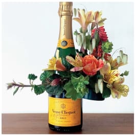 Champagne bottle with a colorful floral arrangement attached
