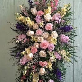 Tall standing floral spray with pink and cream roses and mixed pastel blooms