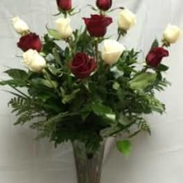 Red and white roses arranged in a clear vase