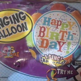 Packaged singing birthday balloon with colorful text and music notes