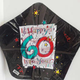 Black 60th birthday foil balloon with colorful music notes and stars