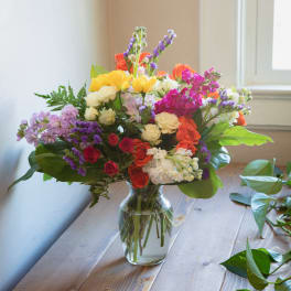 Mixed bouquet of colorful flowers in a clear glass vase