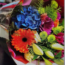 Colorful bouquet with blue hydrangea, orange gerbera daisy, and yellow tulips