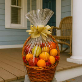 Basket of assorted fruit wrapped in clear cellophane with a gold bow