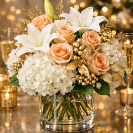 Peach roses and white lilies in a clear glass vase