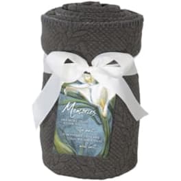Dark woven gift basket tied with a white ribbon and a floral label