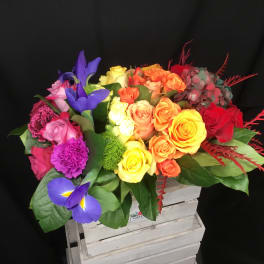 Colorful bouquet of roses and irises in a white crate