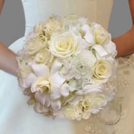 Bride holding a white bouquet of roses and orchids