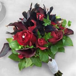 Red rose bouquet with dark foliage and green leaves