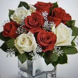 Red and white roses arranged in a clear square vase
