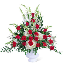 Red roses and white carnations in a white vase